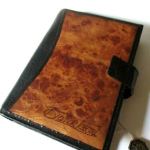 May include: A black leather wallet with a wood grain pattern and the text "Danke Schoen" embossed on the front.