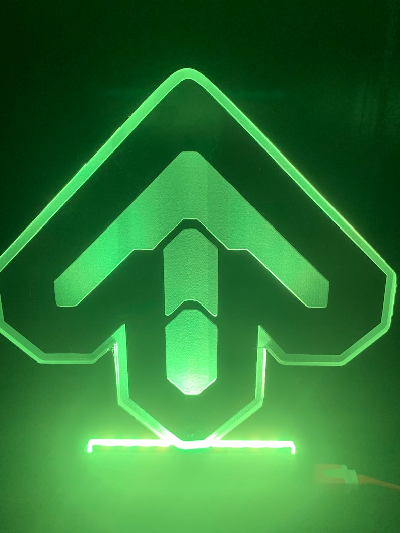 May include: A green illuminated acrylic sign with a stylized arrow pointing upwards. The sign is on a black background.