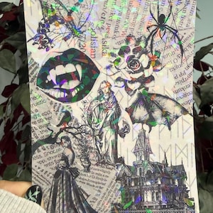 Puede incluir: Una hoja de pegatinas holográficas con ilustraciones góticas. Incluye una mariposa, colmillos de vampiro, una rosa, una araña, una mujer con un vestido, un murciélago y una casa embrujada. El fondo es un collage de recortes de periódico.