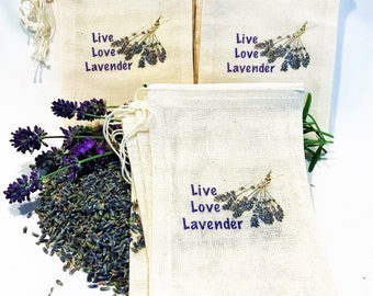 May include: A stack of six natural linen drawstring bags with the text "Live Love Lavender" and a purple lavender sprig printed on each bag. Dried lavender flowers are scattered on a white surface.