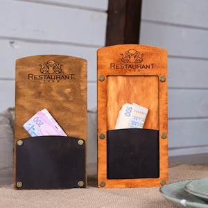 May include: Two wooden menu holders with a black leather pocket. The holders have a brown stain finish and a logo that says "Restaurant Logo".