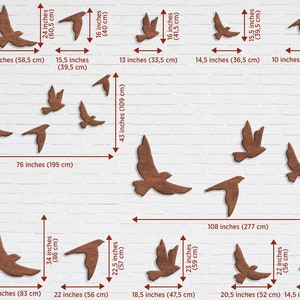 May include: A wall decor set of 14 wooden bird cutouts in various sizes and shapes. The birds are arranged in a staggered pattern on a white brick wall. The largest bird measures 60 inches (155 cm) tall and the smallest bird measures 10 inches (26 cm) wide.