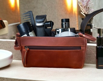 May include: A brown leather travel bag with a zipper closure. The bag is filled with toiletries, including a comb, electric razor, and a bottle of cologne.