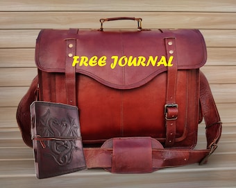 May include: A brown leather satchel with a shoulder strap and a smaller brown leather journal with a dragon design. The satchel has a metal handle and a buckle closure. The text "FREE JOURNAL" is printed on the front of the satchel.