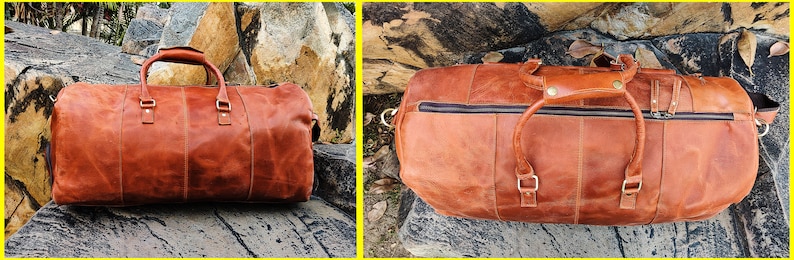 May include: A brown leather duffel bag with two top handles and a zipper closure. The bag is sitting on a rocky surface.
