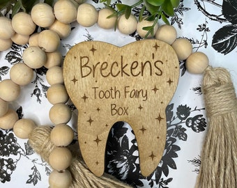 May include: A wooden tooth fairy box shaped like a tooth with the text "Brecken's Tooth Fairy Box" and a brown tassel.