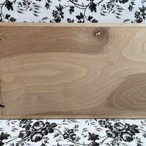 Puede incluir: Un letrero de madera de color marr&oacute;n claro con un borde marr&oacute;n oscuro. El letrero tiene cuatro peque&ntilde;os ganchos de metal negro en las esquinas.