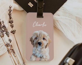 May include: A pink luggage tag with a brown leather strap. The tag features a cartoon illustration of a light brown dog with the name "Charlie" written in white cursive.