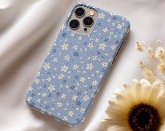 May include: A light blue phone case with a white floral pattern. The case is designed for an iPhone and has a camera cutout.