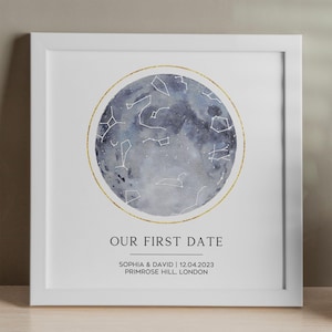 Puede incluir: Impresión enmarcada con una representación en acuarela de un mapa celeste dentro de un círculo dorado. La impresión incluye el texto "OUR FIRST DATE" y los nombres "SOPHIA & DAVID" con fecha y lugar.