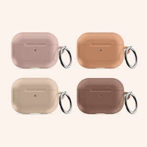 Op de afbeelding: Vier siliconen Airpods-hoesjes met een metalen sleutelhangerlus. De hoesjes zijn in vier verschillende kleuren: roze, oranje, beige en bruin.