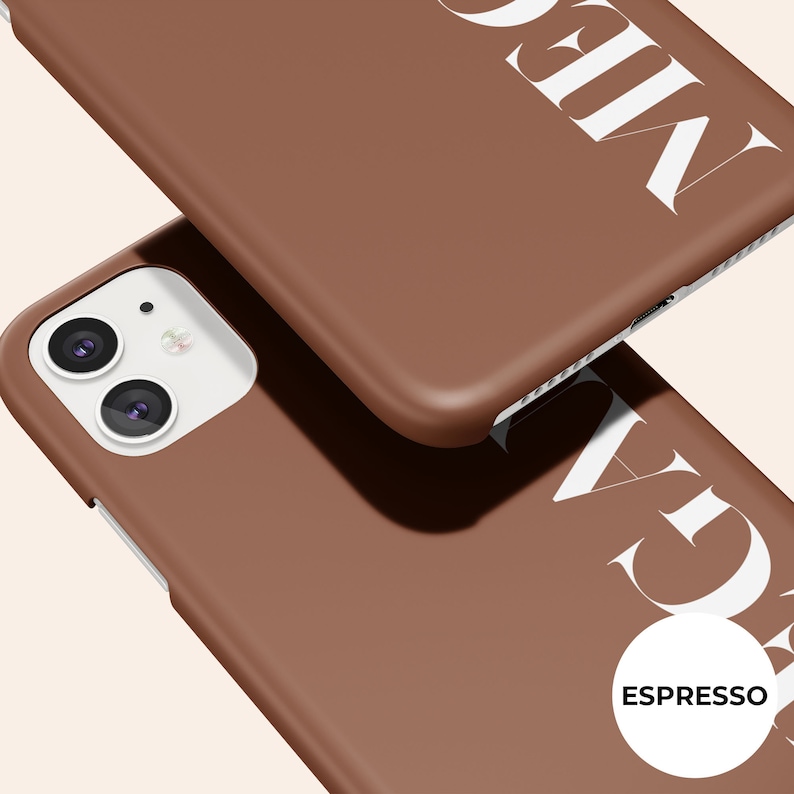 Puede incluir: Dos fundas de tel&eacute;fono marrones con texto blanco. Una funda est&aacute; enfocada, mostrando la palabra "MEGA" en letras blancas grandes. La otra funda est&aacute; ligeramente desenfocada. Un c&iacute;rculo blanco con la palabra "ESPRESSO" est&aacute; en la esquina inferior derecha.