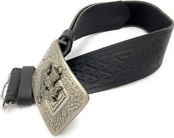 May include: A black leather belt with a Celtic knot design and a silver buckle featuring a thistle design.