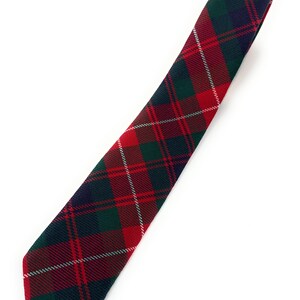 May include: A necktie featuring a classic tartan plaid pattern in shades of deep red, forest green, and navy blue, accented with thin white diagonal lines. The fabric has a visible woven texture, and the tie is presented in a straight, flat orientation.