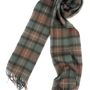 May include: A plaid scarf in shades of gray, brown, and teal with orange accents. The scarf has a fringed edge and is displayed on a white background. The pattern is a classic tartan design.