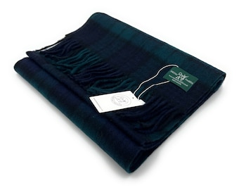 May include: A dark blue and green plaid scarf with fringe. The scarf is folded and has a white tag attached with the text "DARTAN TWEEDS" and a website address.