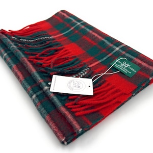 May include: Red, green, and white plaid scarf with fringe. The scarf has a tag that says "Harris Tweed" with a website address.
