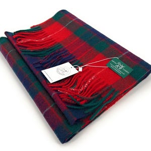 May include: Red, green, and blue plaid wool scarf with fringe. The scarf is folded and has a tag attached that says "Tartan Tweeds".