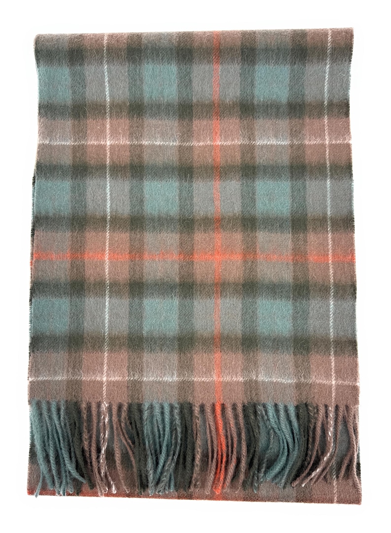 May include: A rectangular scarf with a plaid pattern in shades of gray, teal, and brown, accented with thin white and orange stripes. The scarf has a fringed edge. This accessory is suitable for cold weather.