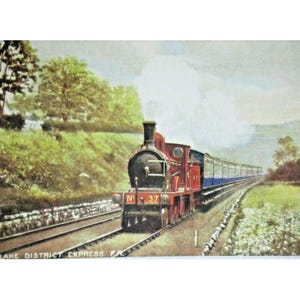 May include: A vintage postcard illustration of a red steam locomotive numbered 37, labeled Lake District Express, pulling a blue passenger train along tracks through a green landscape with trees and white smoke billowing from the engine stack.