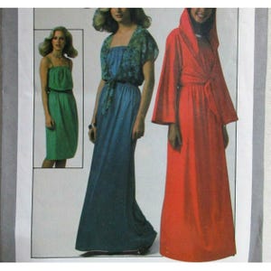 May include: A sewing pattern illustration featuring three garments: a knee-length green dress, a floor-length blue dress with a matching floral print bolero, and a floor-length red hooded robe with long sleeves and a tie-front closure.