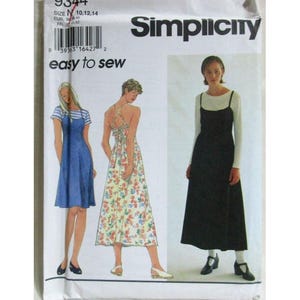 May include: A Simplicity 9344 sewing pattern envelope featuring illustrations of three variations of a sleeveless dress. The designs include a blue knee-length dress, a floral print midi dress with a crisscross back, and a long black dress.
