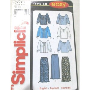 May include: A Simplicity sewing pattern envelope, number 8849, size A, featuring illustrations of various long-sleeved blouses and long skirts. The cover displays the text IT'S SO easy and Simplicity, with diagrams showing different fabric patterns.