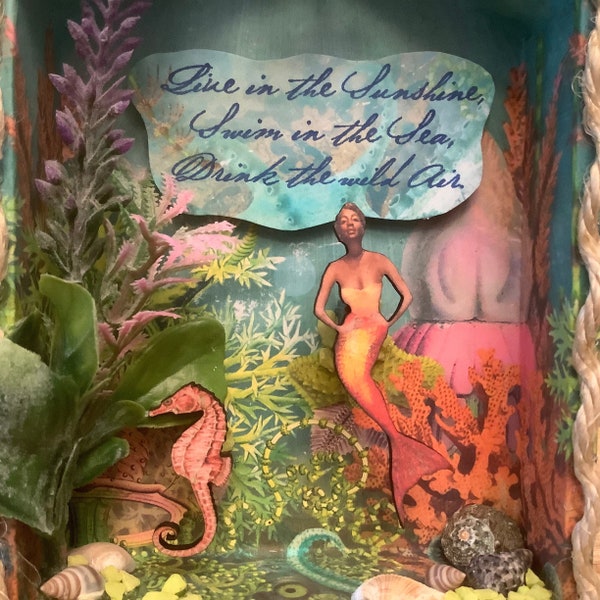 Jazzy mermaid in sea life diorama with inspirational saying.