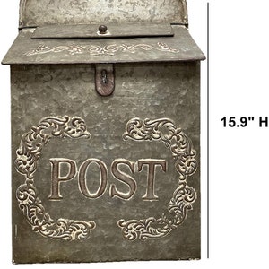 May include: A galvanized metal wall-mounted mailbox with a hinged lid and a decorative embossed frame surrounding the word POST. The mailbox features a weathered gray finish and measures 15.9 inches in height and 11 inches in width.