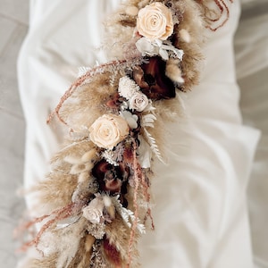 Burgundy and beige dried flower wedding garland with preserved roses, pampas grass, hydrangea and amaranthus. Boho wedding table garland for sweetheart table, wedding arch or fireplace decor. Rustic fall wedding flower arrangement in neutral and burgundy tones with preserved and dried flowers. Matching wedding flower set available.