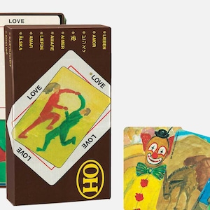 May include: A brown box and cards with the word "LOVE" in multiple languages. The cards feature illustrations of figures and a clown. The box has the text "LOVE" and "OH".
