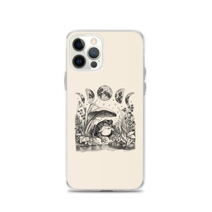 May include: A white iPhone case featuring a black and white illustration of a frog sitting under a mushroom with a crescent moon and stars in the background.