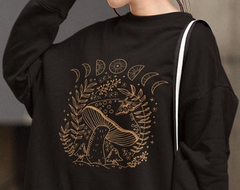 May include: Black sweatshirt with a gold graphic of a mushroom in a forest with moons and stars. The text "DOOOO" is above the mushroom.