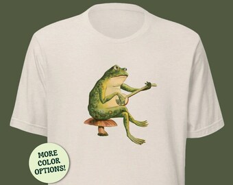 Cute Frog Playing Banjo Unisex T-Shirt, Phorg Sitting on Mushroom, Cottagecore Toad, Goblincore Froge, Playing Guitar On Fungi, Gift For Her