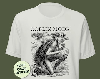 May include: Off-white t-shirt featuring a black and white illustration of a goblin and the words "GOBLIN MODE" above the image. A circular button on the lower left corner reads "MORE COLOR OPTIONS!"