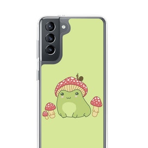 May include: A green frog wearing a red and white mushroom hat with a snail on top. The frog is surrounded by three red and white mushrooms. The background is a light green colour.