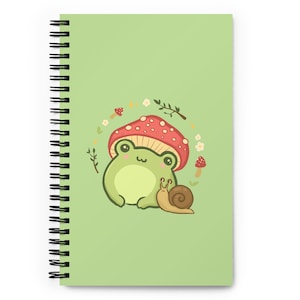 Peut inclure: Une grenouille verte avec une expression joyeuse est assise sous un champignon rouge et blanc avec un escargot à côté. La grenouille et l'escargot sont entourés de feuilles vertes, de fleurs blanches et de petits champignons rouges. L'arrière-plan est vert clair.