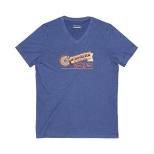 Op de afbeelding: Blauw V-hals T-shirt met de tekst "Introvert maar bereid om kruissteek te bespreken". Het ontwerp bevat een banner en een cirkelvormig embleem met kruissteekdetails. Het shirt is gemaakt van een zacht, comfortabel materiaal.