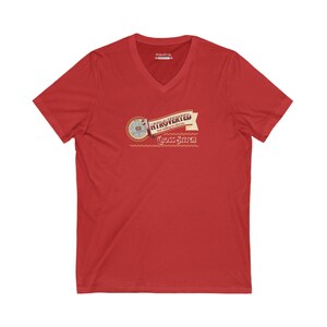 Op de afbeelding: Rood V-hals T-shirt met de tekst "Introvert maar bereid om kruissteek te bespreken" in een bannerontwerp. Het shirt heeft een cirkelvormige afbeelding met kruissteekelementen.