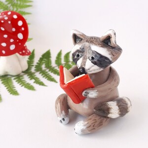 Raccoon ornament forest home decor, Ceramic raccoon figurine for bookshelf decor, Cute raccoon reading figure book nook raccoon miniature