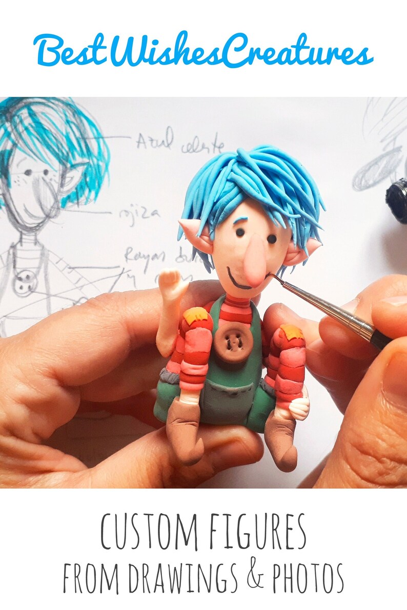 May include: A blue-haired, red and green-clothed, clay figurine with a large nose and a friendly smile. The figurine is being painted with a small brush. The image text reads "Best Wishes Creatures" and "CUSTOM FIGURES FROM DRAWINGS & PHOTOS".