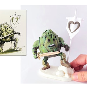 May include: A green artichoke figurine wearing armor and holding a sword, standing on a white base with a white flag with a heart design.