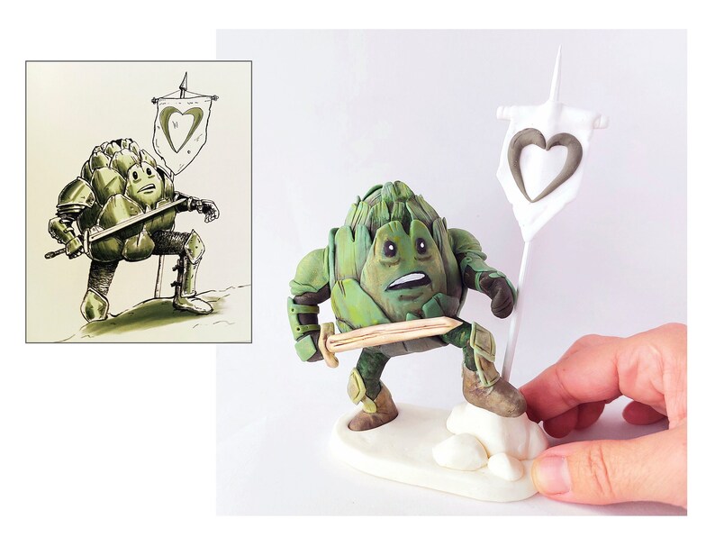 May include: A green artichoke figurine wearing armor and holding a sword, standing on a white base with a white flag with a heart design.