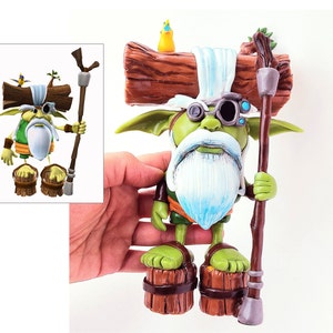May include: A green and white gnome figurine with a long white beard, wearing a green and brown outfit, holding a wooden staff. The gnome is wearing a pair of goggles and has a log on its head. The gnome is standing on two wooden barrels.