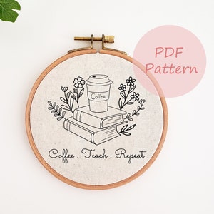 May include: A white embroidery hoop with a black line drawing of a coffee cup, books, and flowers. The text "Coffee. Teach. Repeat." is written below the drawing.