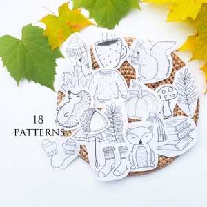 May include: A set of 18 black and white printable stickers featuring autumn and winter themes. The stickers include a squirrel, a hedgehog, a mushroom, a pumpkin, a sweater, a cup of coffee, a pair of mittens, a pair of socks, a fox, a book stack, an umbrella, and a leaf. The text "18 PATTERNS" is also included in the image.