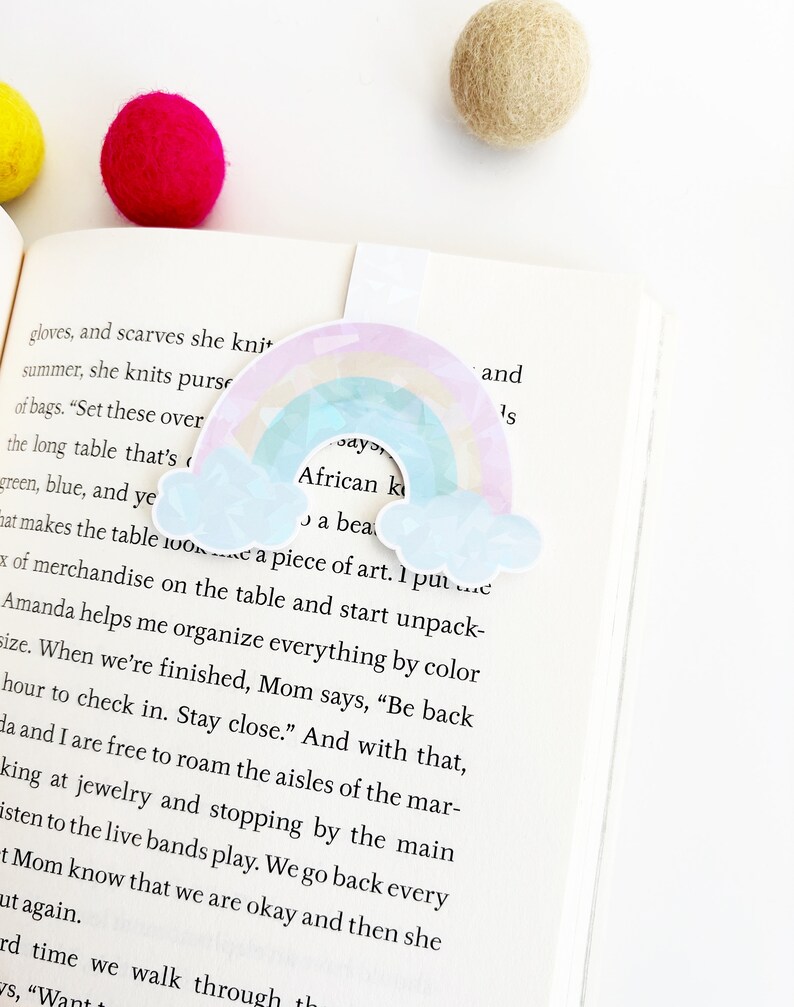 May include: A rainbow-colored bookmark with a cloud design and the text "African Kids Say" and "A beautiful piece of art."