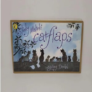 May include: A children's book titled "Slinky Malinki Catflaps" by Lynley Dodd. The cover features a blue sky with white clouds and a group of black cats with green eyes sitting on a wall. The cats are looking at the viewer.