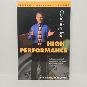 May include: A book titled "Coaching for High Performance" features a man in a blue shirt and patterned tie. The cover includes the text "Eighteen essential elements of personal and professional coaching."