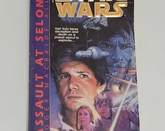 May include: A paperback book cover for the Star Wars novel "Assault at Selonia" by Roger MacBride Allen. The cover features a close-up of Han Solo, Princess Leia, and Luke Skywalker. The book is part of the Corellian Trilogy.
